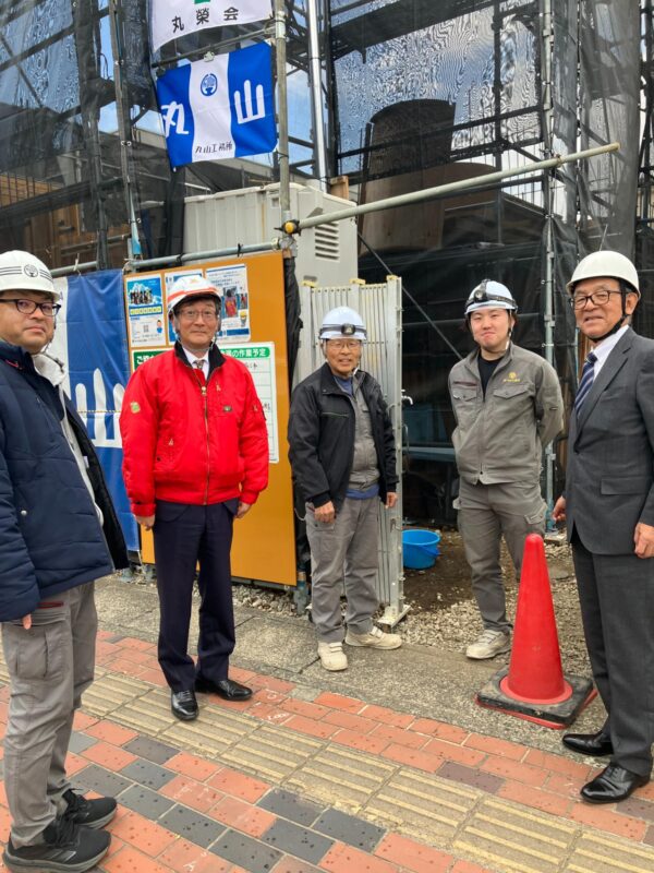 ベテラン監督と若手スタッフが作業するマンション建設現場